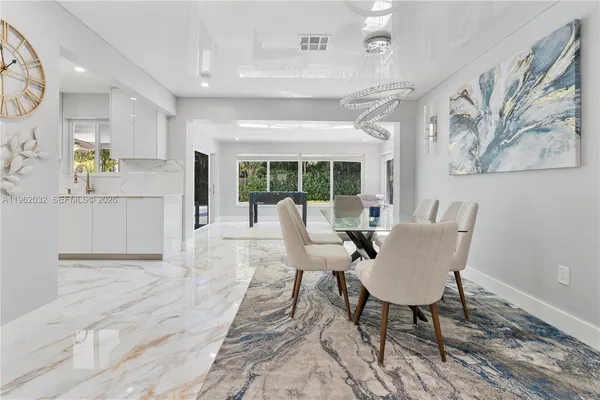 a large kitchen with stainless steel appliances kitchen island granite countertop a sink and a refrigerator