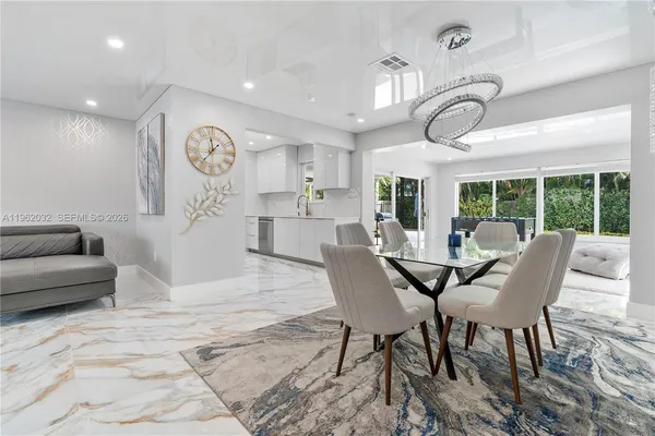 a large white kitchen with a sink stainless steel appliances and cabinets