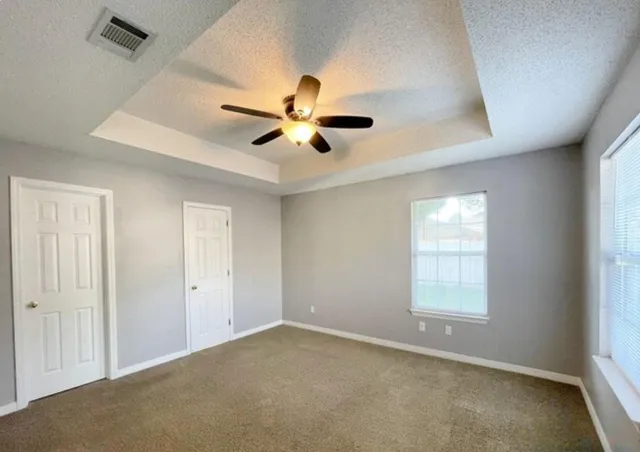 an empty room with a window and a fan