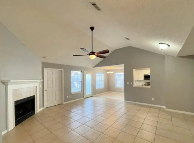 a view of a livingroom with a ceiling fan a fireplace and window