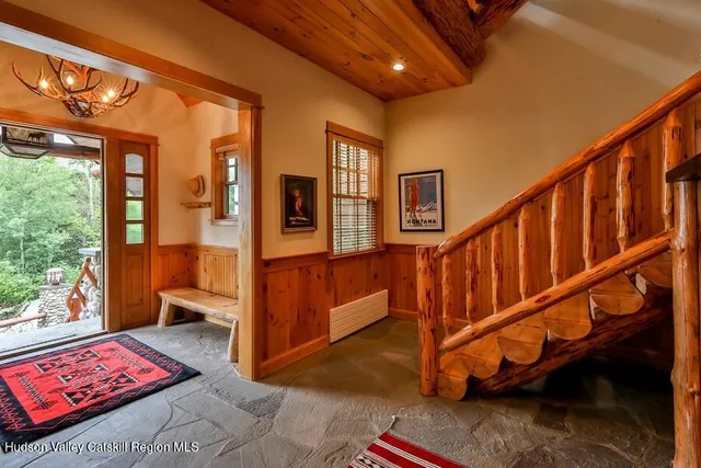 a living room with furniture a rug and a floor to ceiling window