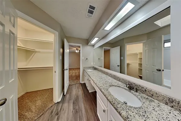 a bathroom with a granite countertop double vanity sink and mirror
