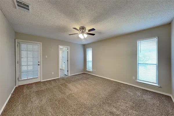 an empty room with fan and windows