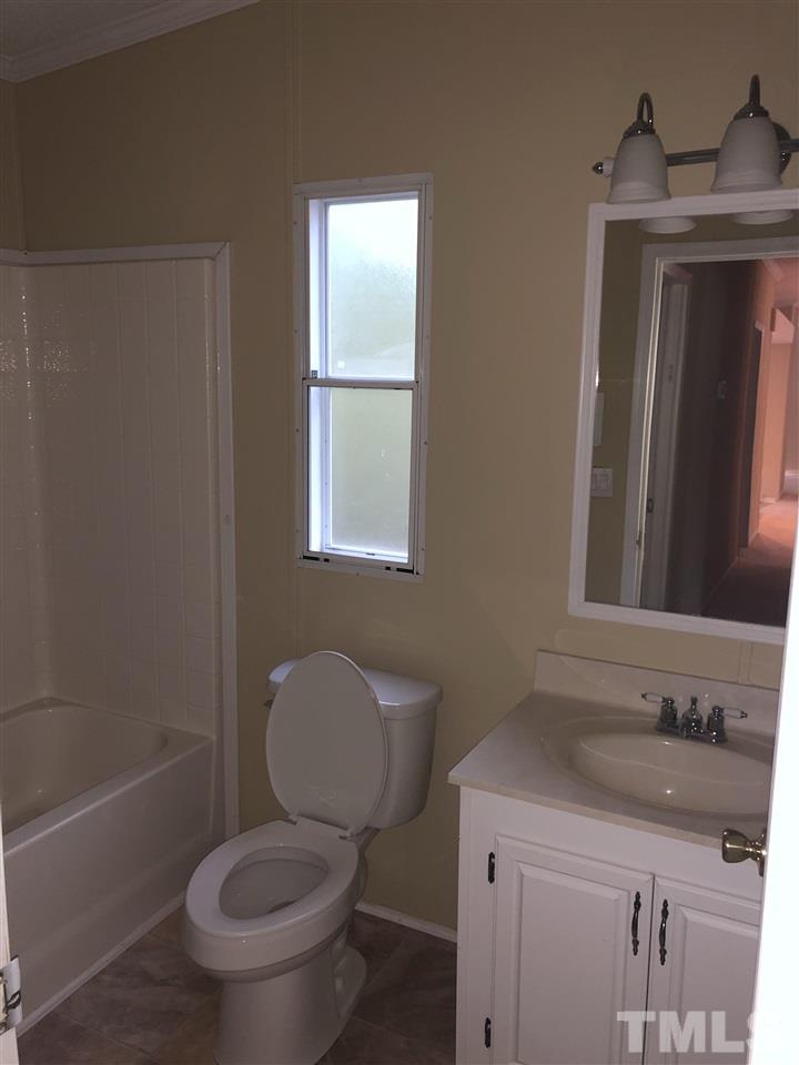 1320 Yakimas Road Raleigh, NC 27603 - Photo 12 of 14 a bathroom with a granite countertop toilet a sink and a bathtub