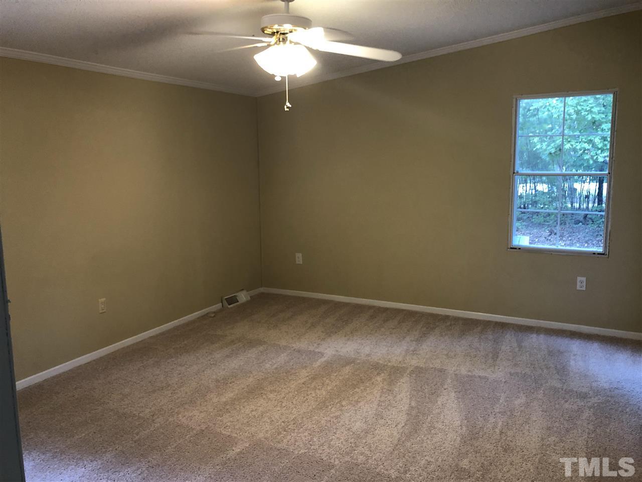 1320 Yakimas Road Raleigh, NC 27603 - Photo 5 of 14 an empty room with windows and chandelier fan