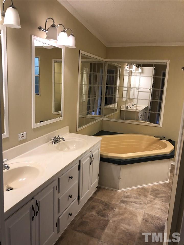 1320 Yakimas Road Raleigh, NC 27603 - Photo 7 of 14 a spacious bathroom with a tub sink and mirror
