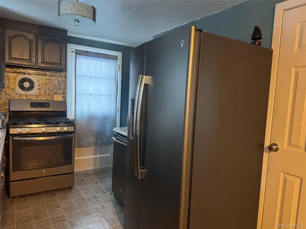 a view of a refrigerator and an stove in a kitchen