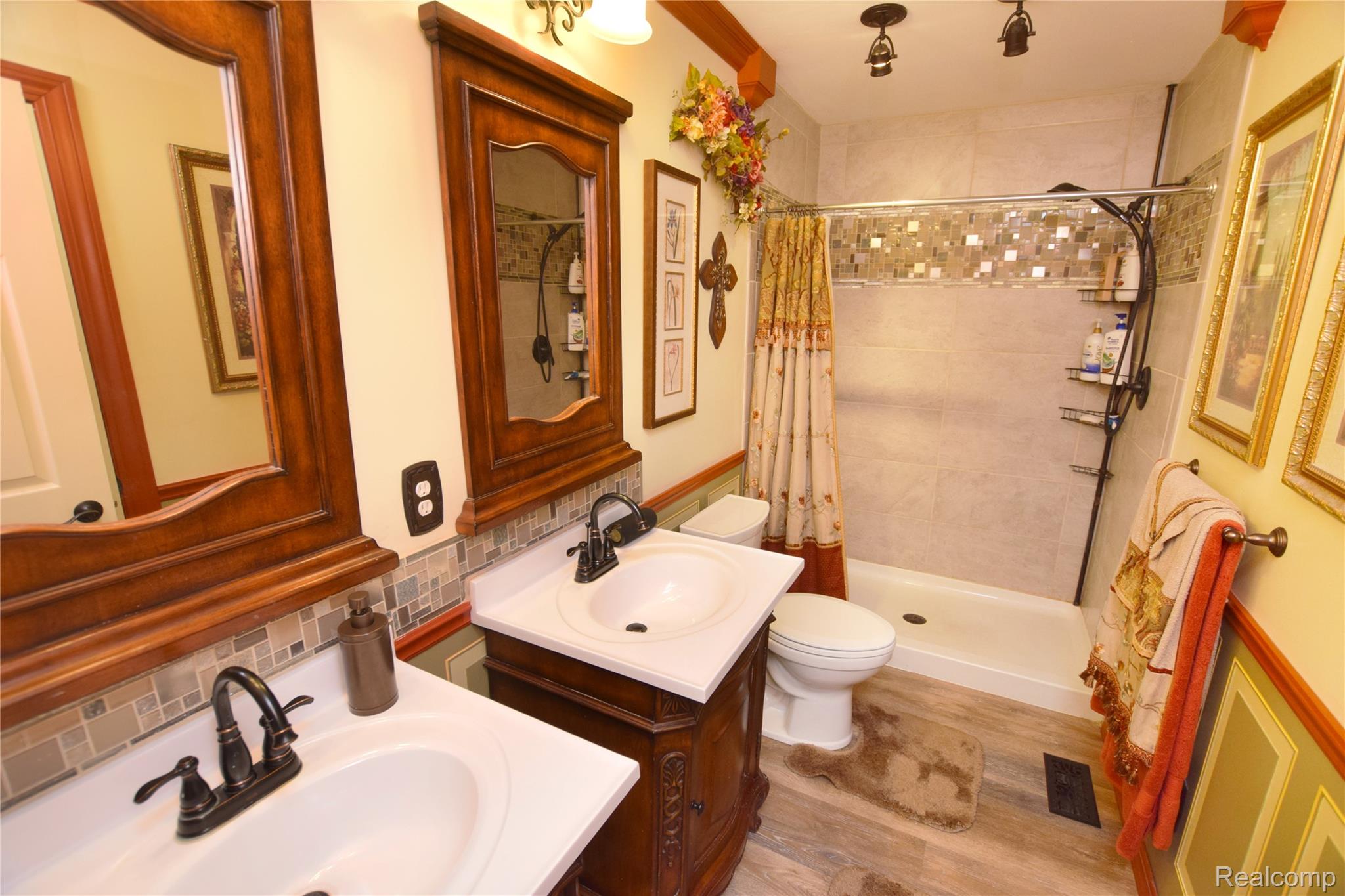 15489 Linden Road Linden, MI 48451 - Photo 8 of 25 Full bath featuring a stall shower, backsplash, two vanities, and light wood-style floors