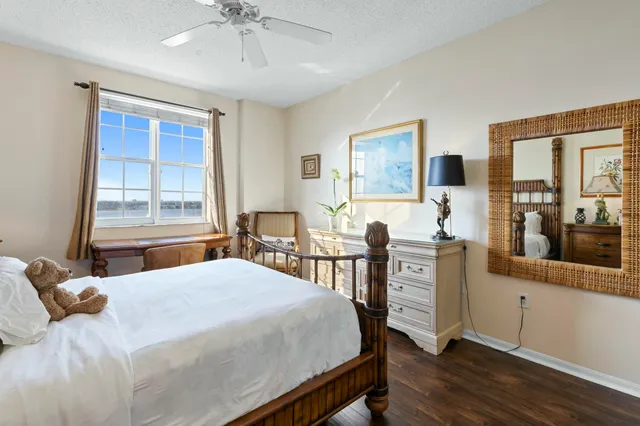 a bedroom with a bed and a large window with wooden floor
