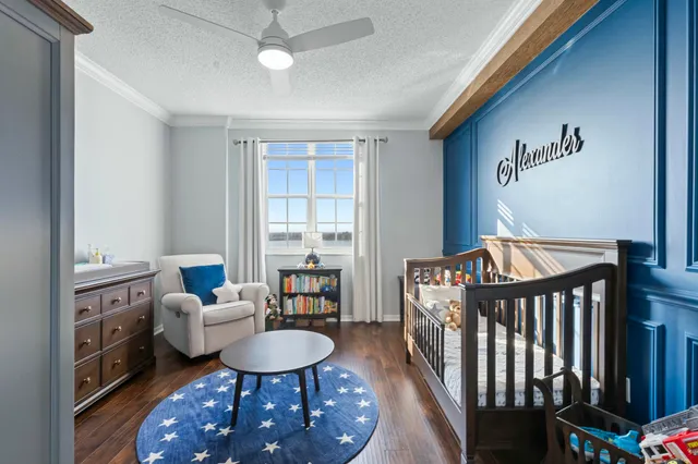 a bedroom with furniture a rug potted plant and a window