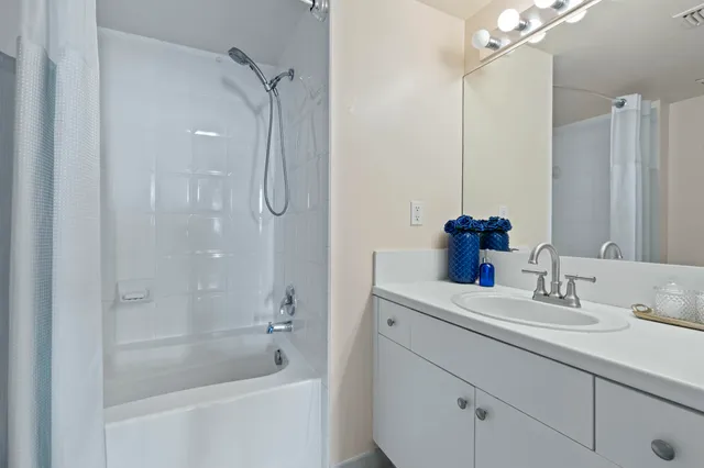 a bathroom with a shower sink vanity and mirror