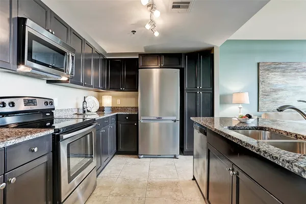 a kitchen with stainless steel appliances granite countertop a sink and stove