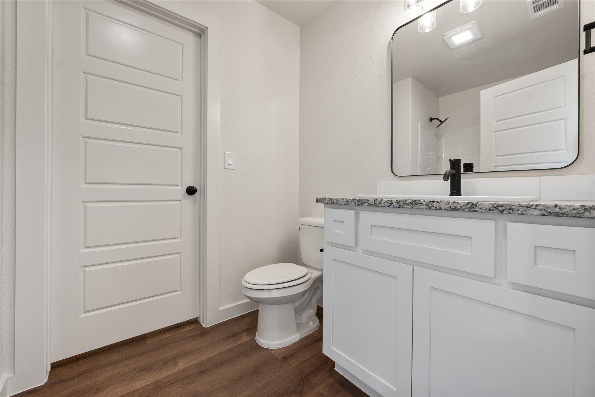 1320 North Colton Avenue Lubbock, TX 79416 - Photo 15 of 22 a bathroom with a granite countertop sink toilet and mirror