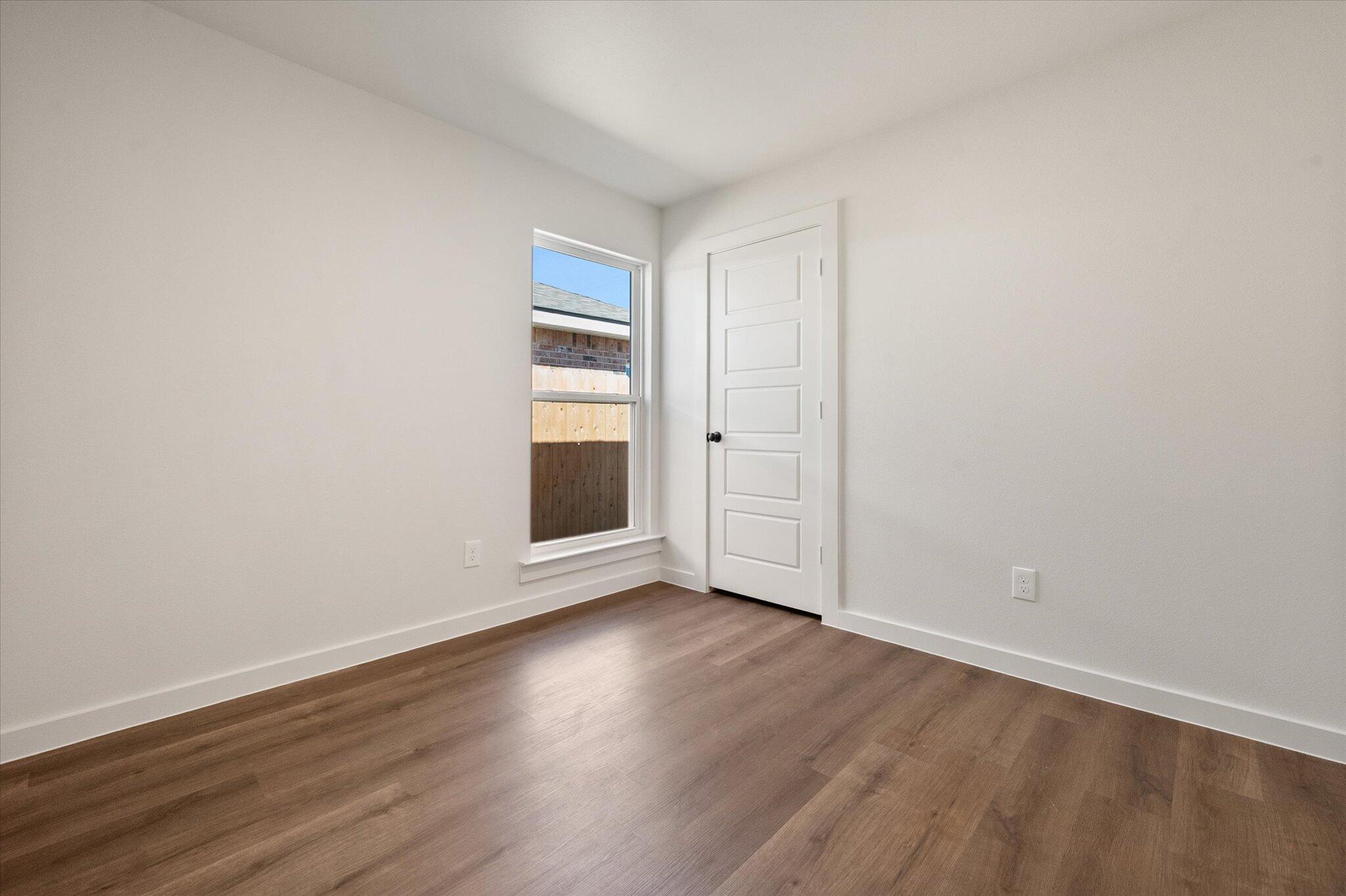 1320 North Colton Avenue Lubbock, TX 79416 - Photo 17 of 22 an empty room with wooden floor and windows