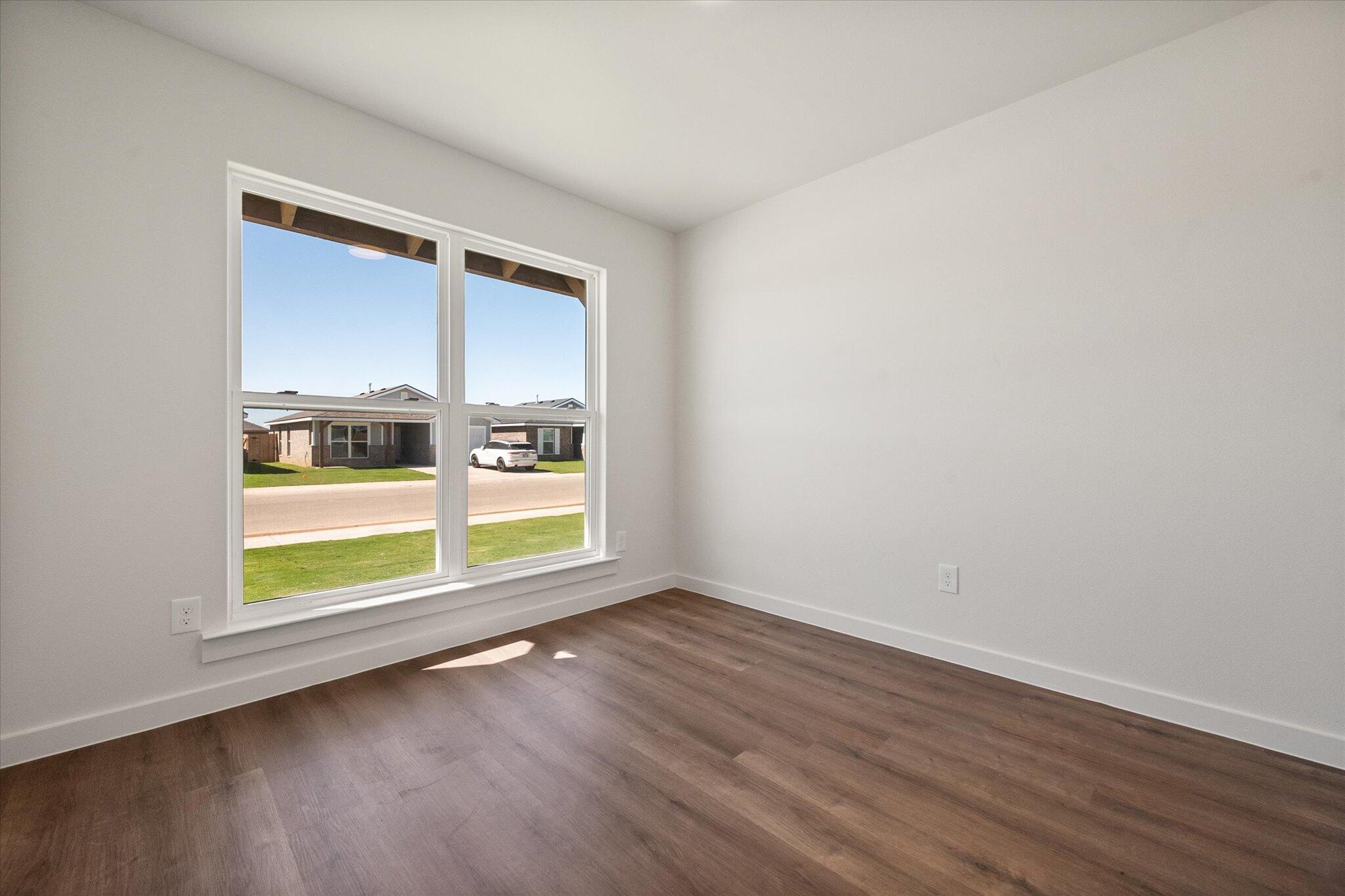 1320 North Colton Avenue Lubbock, TX 79416 - Photo 18 of 22 an empty room with wooden floor and windows