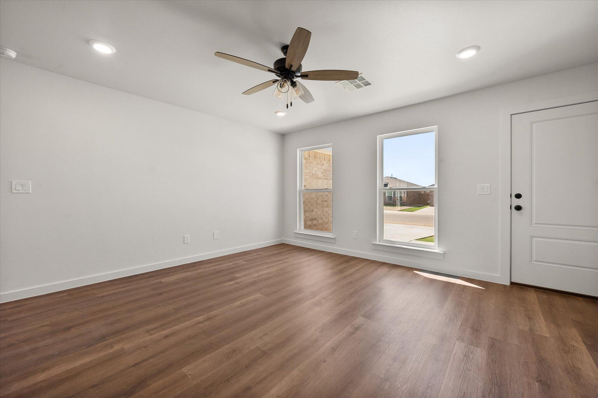 1320 North Colton Avenue Lubbock, TX 79416 - Photo 6 of 22 an empty room with wooden floor ceiling fan and windows
