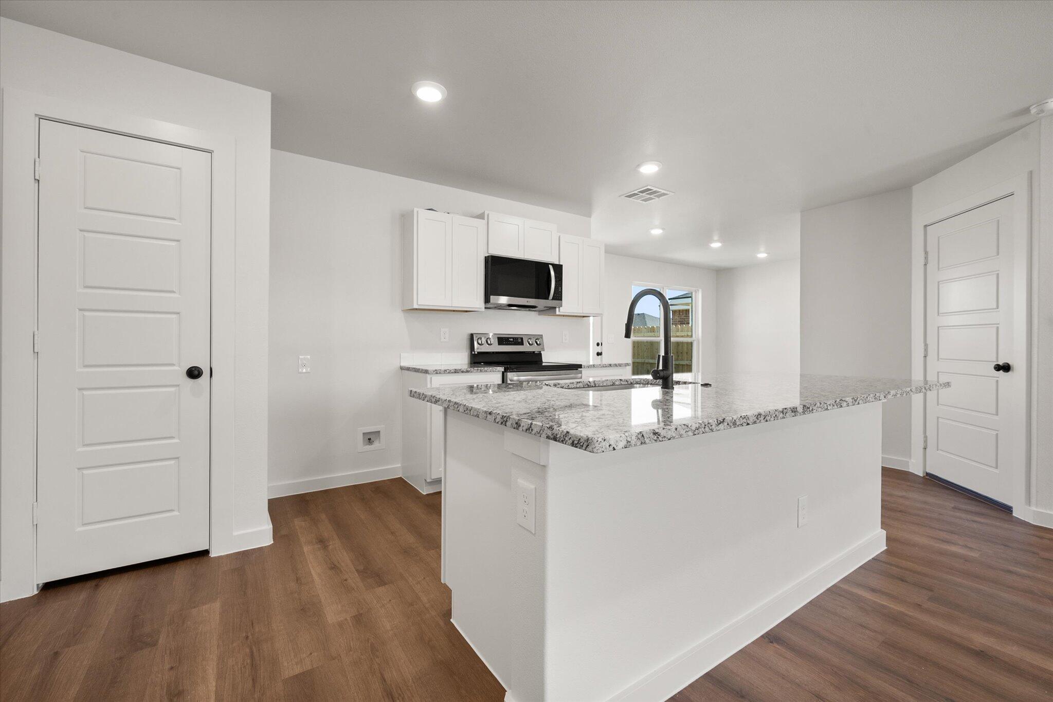1320 North Colton Avenue Lubbock, TX 79416 - Photo 7 of 22 a kitchen with granite countertop a sink and a stove top oven