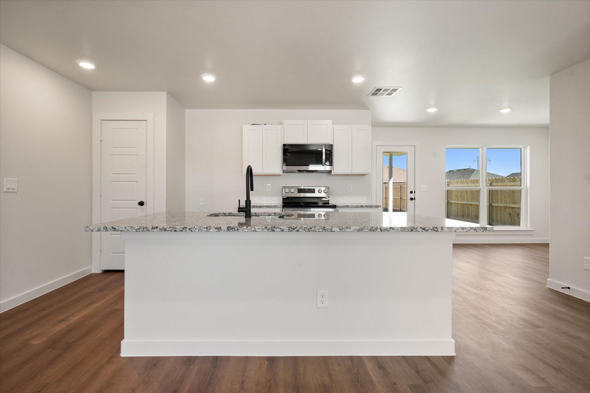 1320 North Colton Avenue Lubbock, TX 79416 - Photo 8 of 22 a view of kitchen with stainless steel appliances granite countertop a stove top oven a sink and a granite counter tops