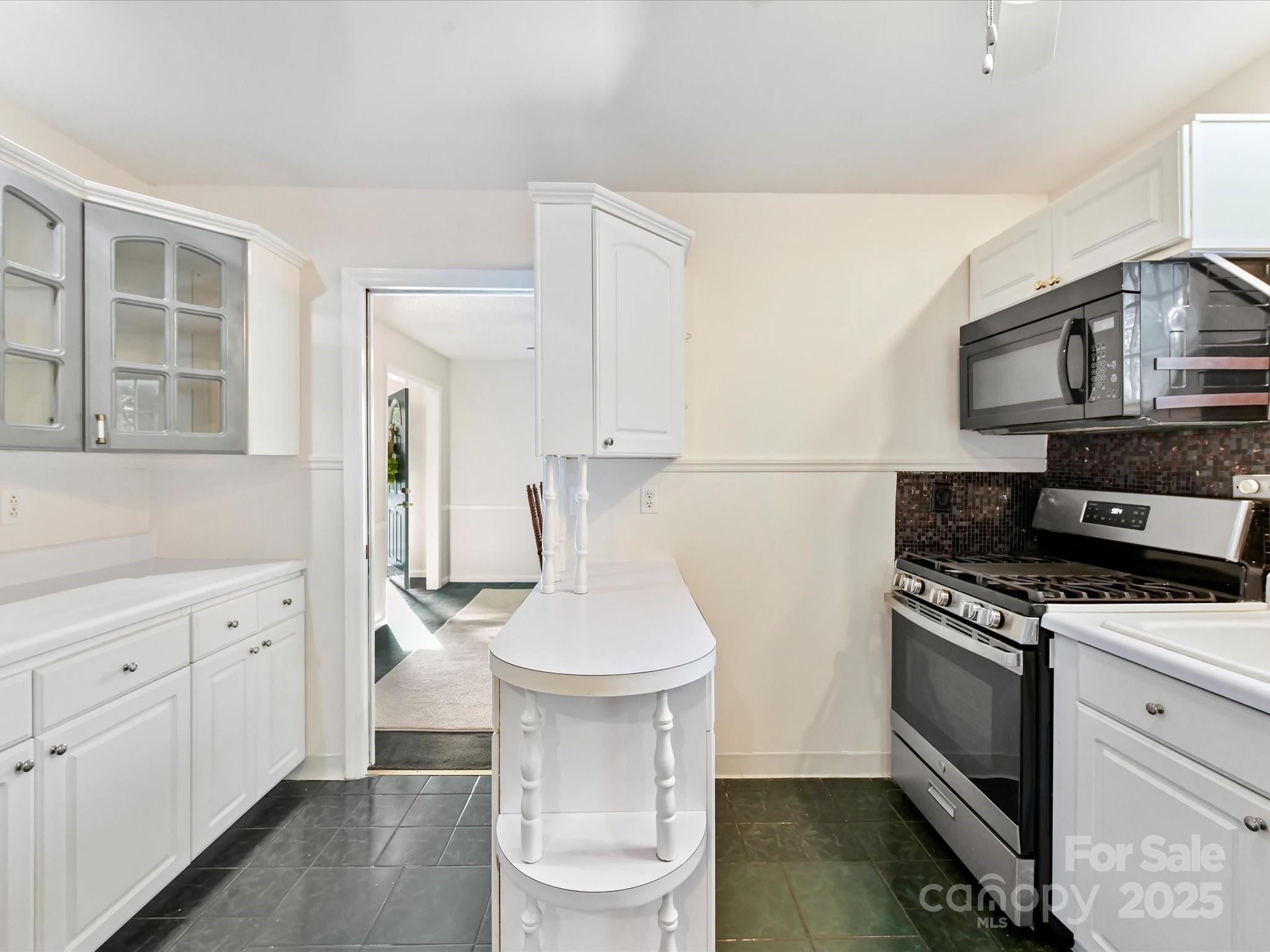 6313 Mill Grove Road Indian Trail, NC 28079 - Photo 19 of 47 a kitchen with stainless steel appliances a sink a stove a microwave and cabinets