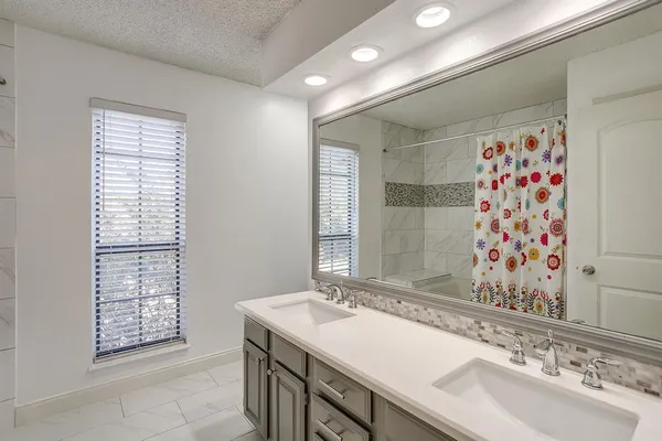 a bathroom with a sink double vanity and a shower