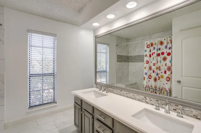 a bathroom with a sink double vanity and a shower