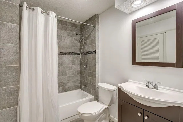 a bathroom with a sink toilet a mirror and shower