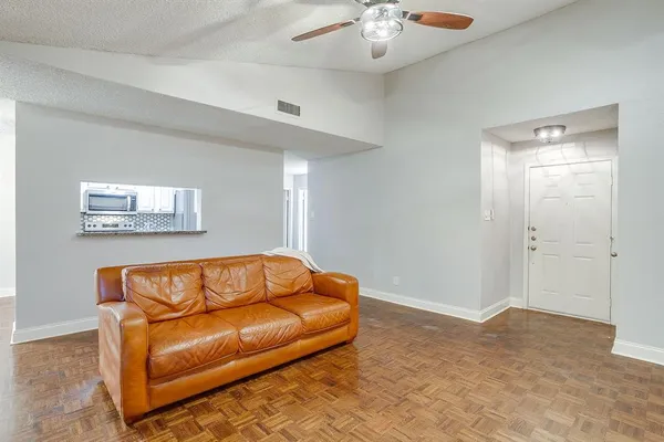 a blue couch sitting in a living room with a chandelier