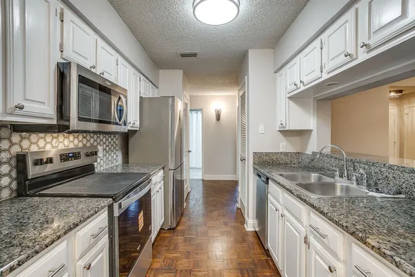 a kitchen with stainless steel appliances granite countertop a sink stove and cabinets