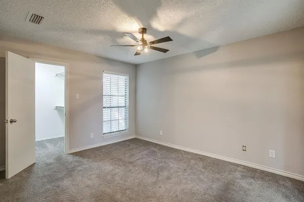 an empty room with windows and fan