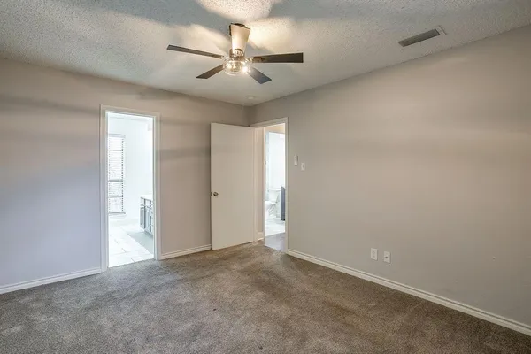 an empty room with a ceiling fan and a window