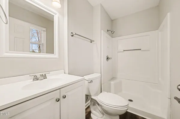a bathroom with a sink toilet vanity and shower