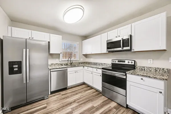 a kitchen with stainless steel appliances granite countertop a stove a sink and a refrigerator