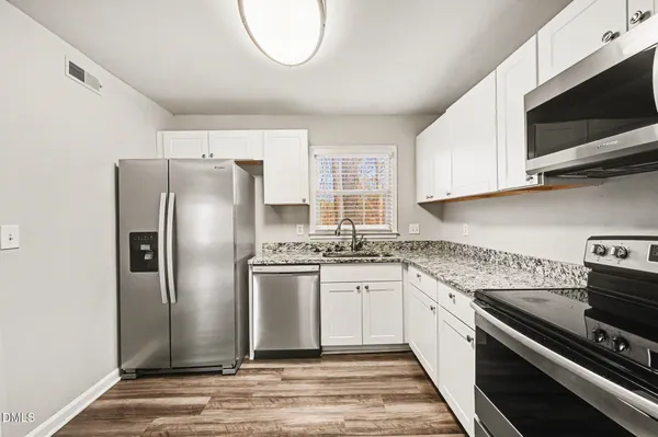 a kitchen with stainless steel appliances granite countertop a stove a refrigerator and a microwave
