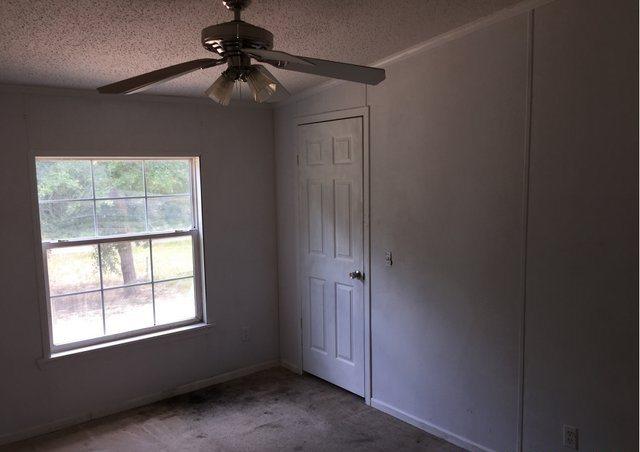 1054 Reeves Road Baker, FL 32531 - Photo 11 of 14 an empty room with windows and fan