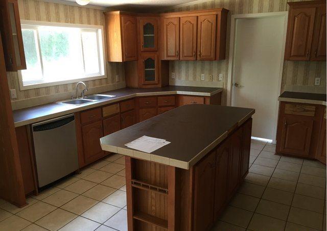 1054 Reeves Road Baker, FL 32531 - Photo 5 of 14 a kitchen with a sink stove and cabinets
