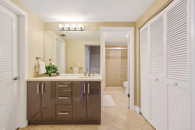 a bathroom with a double vanity sink and mirror with shower