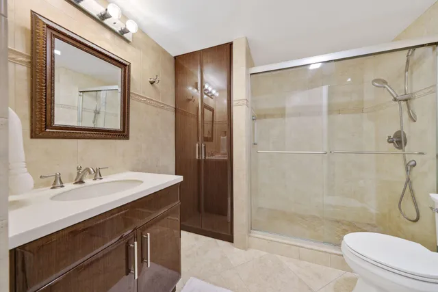 a bathroom with a sink a toilet and shower