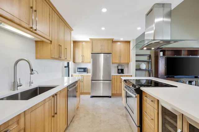 a kitchen filled a sink a counter and stainless steel appliances