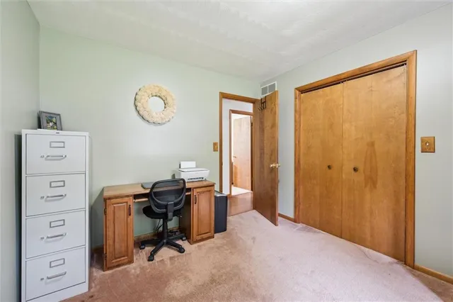 a view of a workspace with furniture and a window