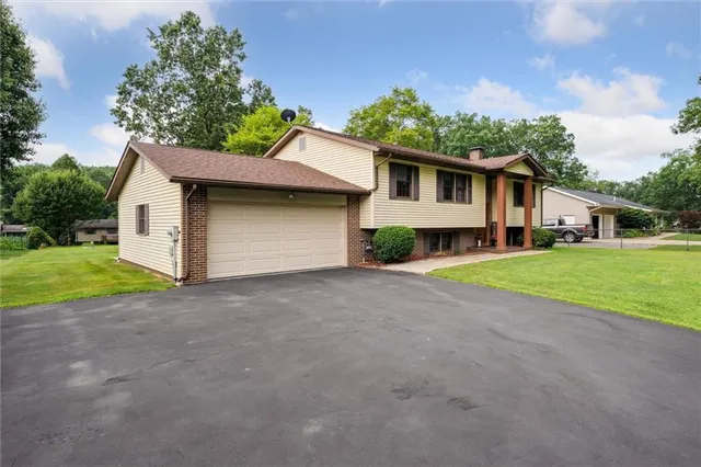 a view of a house with a yard and garage