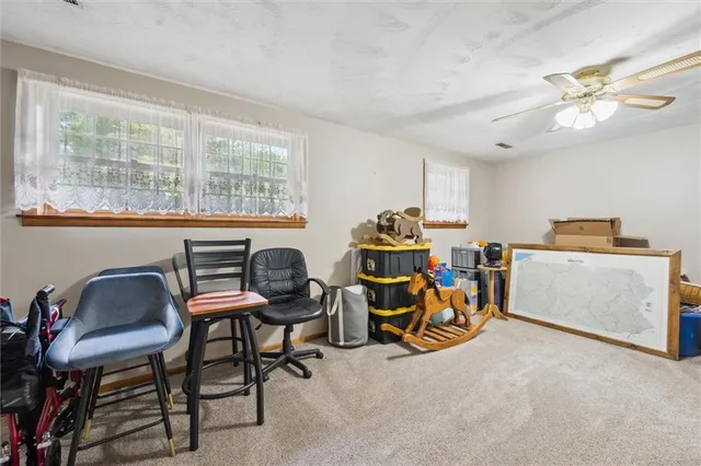 a view of a workspace with furniture and a window