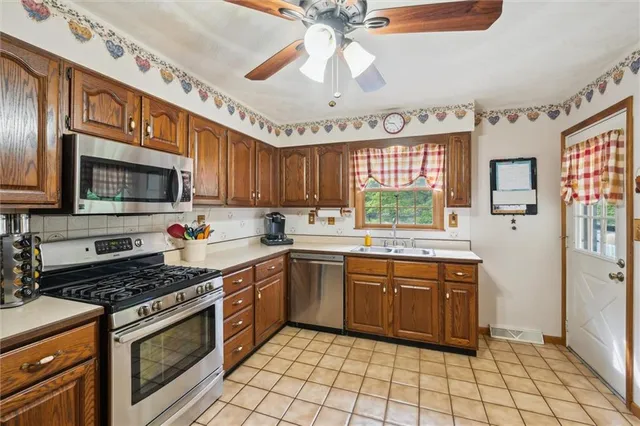 a kitchen with stainless steel appliances granite countertop a stove cabinets and window