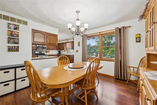 a view of a dining room with furniture a chandelier and wooden floor