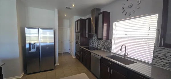 a kitchen with stainless steel appliances granite countertop a refrigerator and a sink