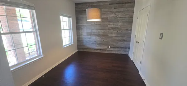 a view of a hallway with wooden floor and windows