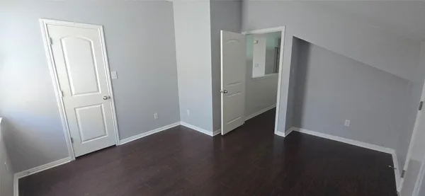 an empty room with wooden floor and closet