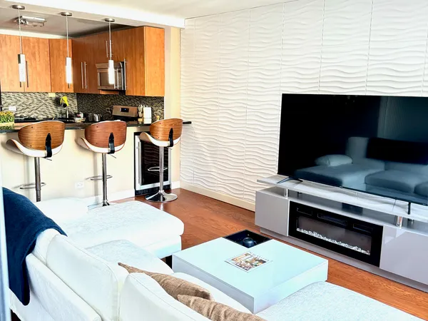 a living room with furniture a flat screen tv and a large window