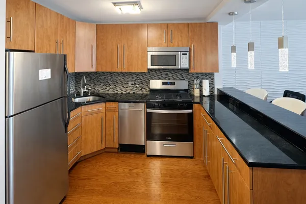 a kitchen with stainless steel appliances a stove refrigerator sink and cabinets