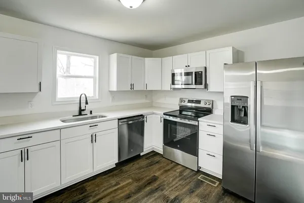 a kitchen with cabinets stainless steel appliances and window
