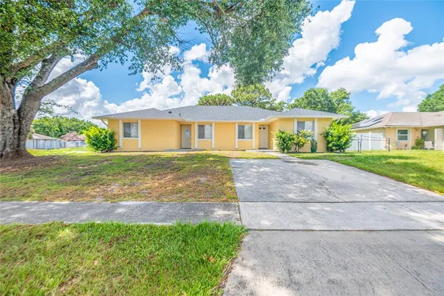 a front view of a house with a yard and trees